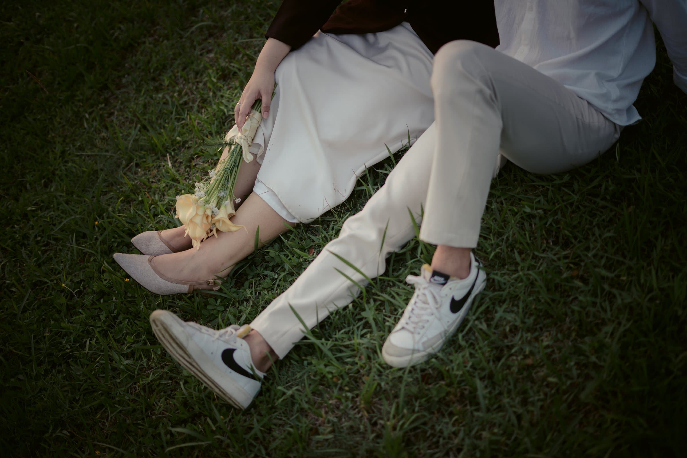 Detail sepatu Laras dan Kiki saat duduk di rumput